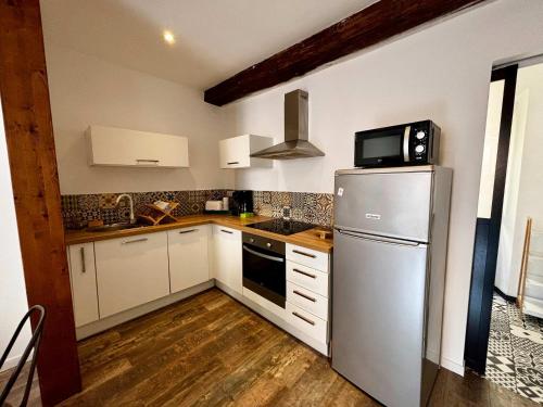  La cuisine est équipée de placards blancs et d'un réfrigérateur. dans l'établissement Casamea - Rue Fesch, Famille, Wifi, Clim, à Ajaccio