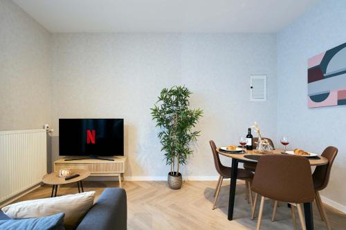 a living room with a table and a tv at Central City Escape Modern Studio Near Everything in Eindhoven