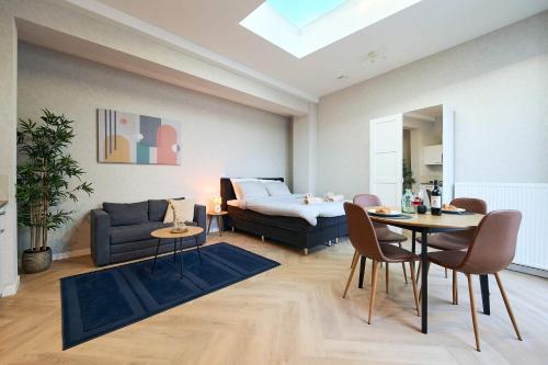 a living room with a bed and a table and chairs at Central City Escape Modern Studio Near Everything in Eindhoven