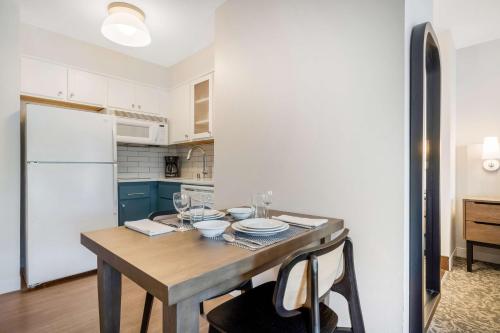 a kitchen with a wooden table and a white refrigerator at Sonesta ES Suites Portland Vancouver 41st Street in Vancouver