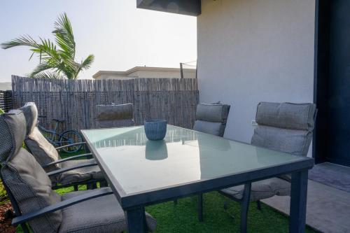 a glass table and chairs on a patio at נופי ארבל in Livnim