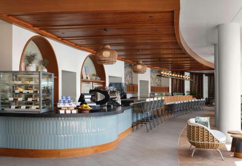 a restaurant with a bar with chairs and tables at The Royal Sonesta Kauai Resort Lihue in Lihue