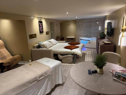 ヴィシーにあるSpa Suite Loftのベッド2台とテーブルがあるホテルの部屋