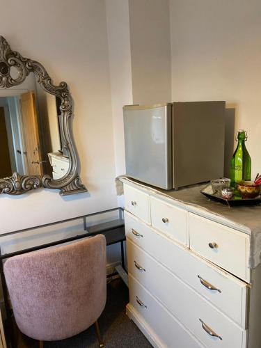 a dresser with a refrigerator on top of it at Upper single bedroom in Cardiff