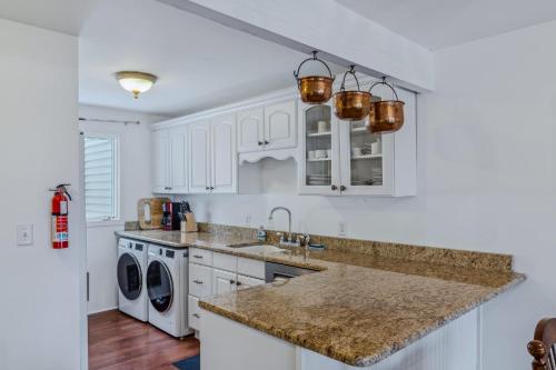 a white kitchen with a sink and a dishwasher at Steps to Ski Trail Fireplace - Kingswood 1B in Quechee