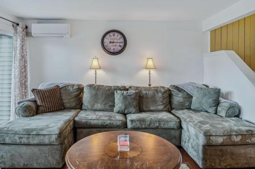 a living room with a couch and a table at Steps to Ski Trail Fireplace - Kingswood 1B in Quechee