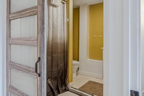 a bathroom with a toilet and a glass door at Steps to Ski Trail Fireplace - Kingswood 1B in Quechee
