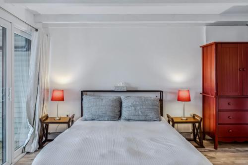 a bedroom with a large white bed with two lamps at Steps to Ski Trail Fireplace - Kingswood 1B in Quechee