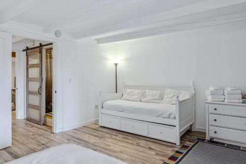 a white bedroom with a white bed and a dresser at Steps to Ski Trail Fireplace - Kingswood 1B in Quechee