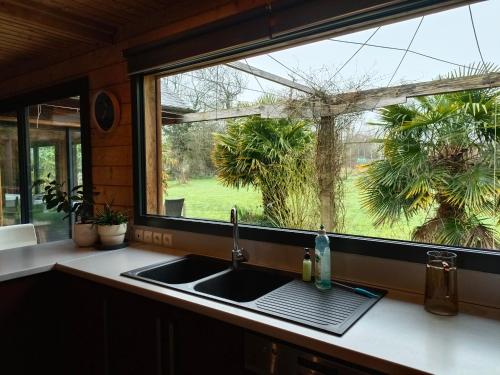 a kitchen counter with a sink and a window at Gîte de la Croix Regnault in Raids