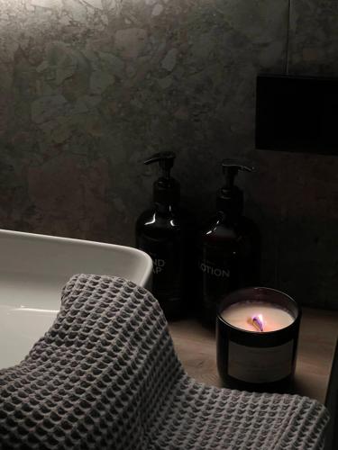 a bathroom with two bottles of soap and a candle at Laska House in Pylypets