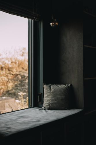 a bed with a pillow in front of a window at Laska House in Pylypets