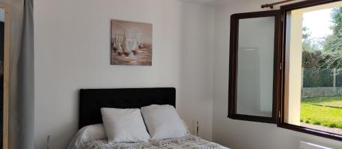 a bedroom with a bed with white pillows and a window at Au fief du château in Airvault