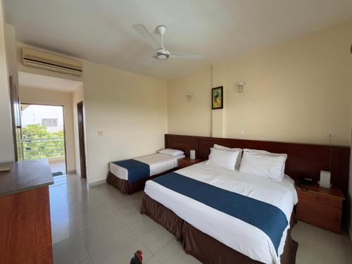 a hotel room with two beds and a window at Hotel Los Puentes Comfacundi in Girardot
