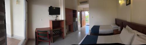 a hotel room with a bed and a television at Hotel Los Puentes Comfacundi in Girardot
