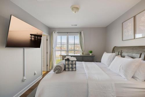 een slaapkamer met een groot wit bed met een raam bij King and Queen Beds with a Gourmet Kitchen in Charlotte