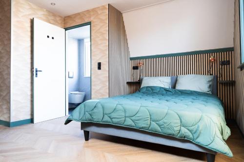 Un dormitorio con una cama grande y un baño. en 1 aan Strand, en Egmond aan Zee