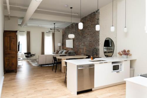 an open kitchen and living room with a brick wall at Maison Place Jacques-Cartier by Luxury In Transit in Montréal