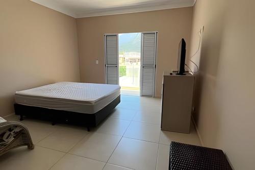 Casa c/ piscina em Cond, Boraceia - SP في بوراسيا: غرفة نوم بها سرير وتلفزيون