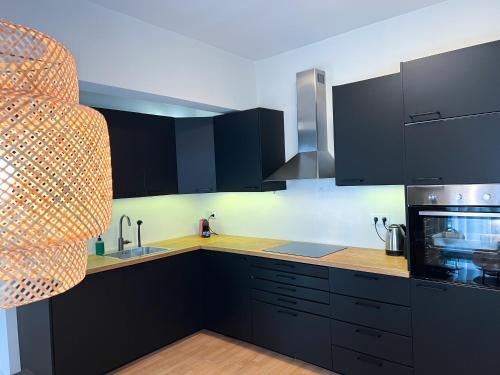 una cucina con armadi neri e lavandino di Downtown Apartment a Kavala