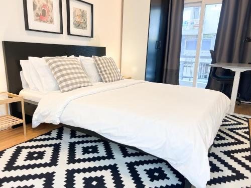 una camera da letto con un letto bianco e un tappeto bianco e nero di Downtown Apartment a Kavala
