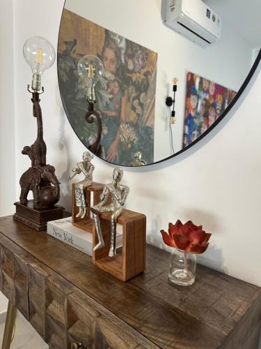 a table with a mirror and some statues on it at -Mari- Cozy Stay at Engomi Near UNIC in Nicosia