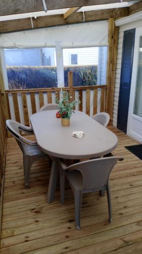 a table and chairs on a porch with a table and chairs at Mobil-home camping 4 étoiles cancale in Cancale