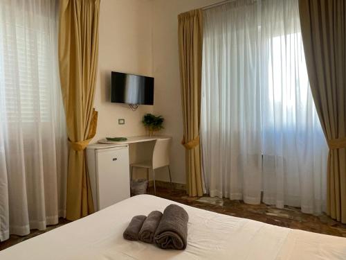 a bedroom with a bed and a desk and a television at Il Giardino Di Flora con Piscina & Jacuzzi in Lecce