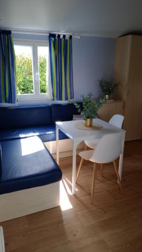 a living room with a blue couch and a table at Mobil-home camping 4 étoiles cancale in Cancale