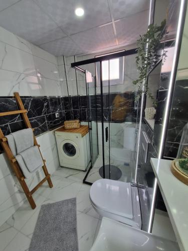 a bathroom with a shower and a washing machine at Central Location 2 Bedroom Apt in Antalya