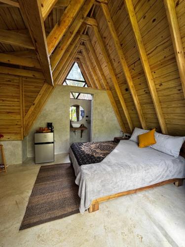 a bedroom with a large bed in an attic at Leisy's Garden Tiny Cabins in El Valle