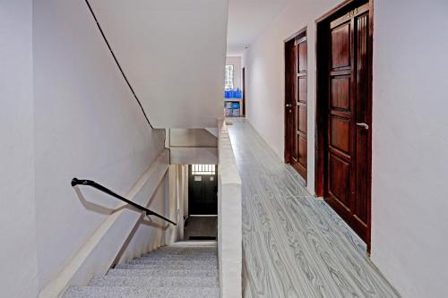 a staircase in a house with wooden doors at Hotel O Aulia Homestay Syariah in Bagam