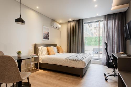 a bedroom with a bed and a desk and a window at WYZ Museum by UPSTREET in Athens