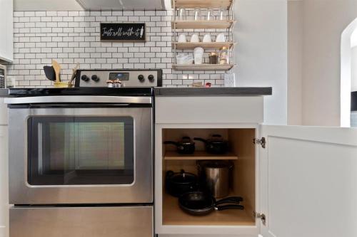 a kitchen with a stainless steel stove and shelves at #StayInMyDistrict Historic Charming Bungalow in Twin Falls