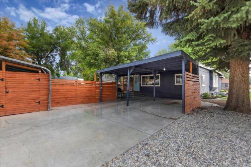 a garage with a black roof and a fence at #StayInMyDistrict Historic Charming Bungalow in Twin Falls