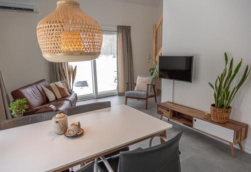 un soggiorno con un tavolo e una TV di Vakantieverblijf Aan de Vaart a Tynaarlo