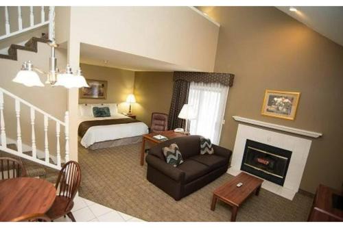 a hotel room with a bed and a living room at Eastlake Suites Hotel & Conference Center By OYO Urbana in Champaign