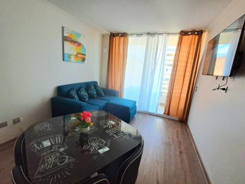 a living room with a blue couch and a table at Hermosa vista al mar dpto Sec Sur Llacolen-Estac- Piscina in Antofagasta