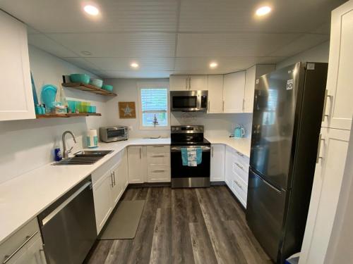 a kitchen with white cabinets and a black refrigerator at Passage view in Campbell River