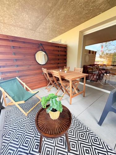 un salon avec une table et des chaises en bois dans l'établissement Élégant et cosy T3 neuf, parking, à Sète