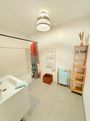 La salle de bains est pourvue d'un lavabo et d'une étagère. dans l'établissement Élégant et cosy T3 neuf, parking, à Sète