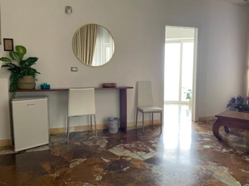 a room with a mirror and a table and chairs at Il Giardino Di Flora con Piscina & Jacuzzi in Lecce