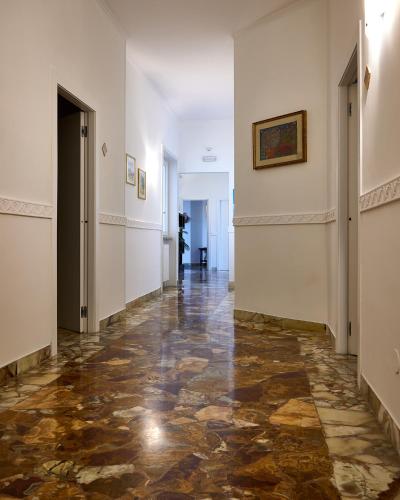 a hallway with a marble floor and white walls at Il Giardino Di Flora con Piscina & Jacuzzi in Lecce