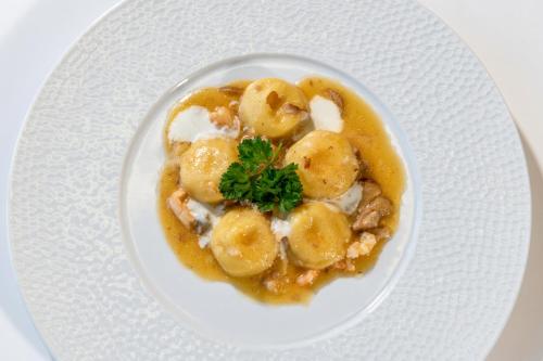 a white plate with a dish of food with dumplings at Hotel Villa Pina Antico Francischiello in Massa Lubrense