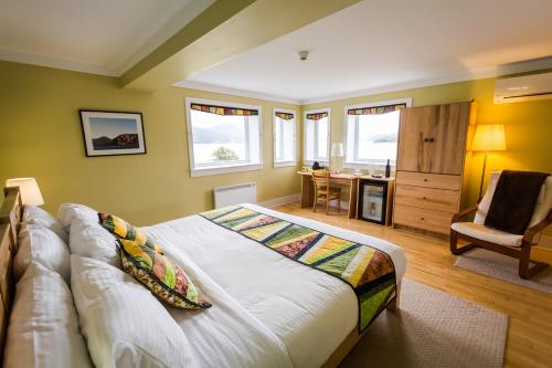 a bedroom with a large bed with a couch and a desk at Neddies Harbour Inn in Norris Point