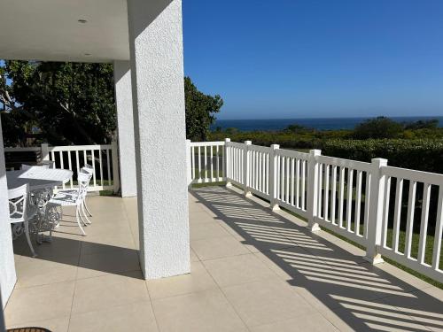 a porch with a white fence and tables and chairs at Views galore in Kleinmond in Kleinmond