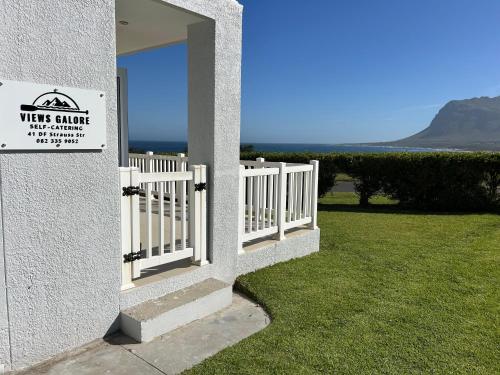 a white fence with a sign on the side of a building at Views galore in Kleinmond in Kleinmond