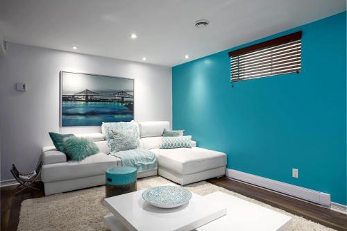 a living room with a couch and a blue wall at Tranquille Discret Privé in Laval