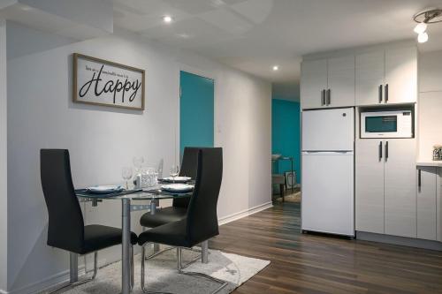 a kitchen with a table and chairs and a refrigerator at Tranquille Discret Privé in Laval