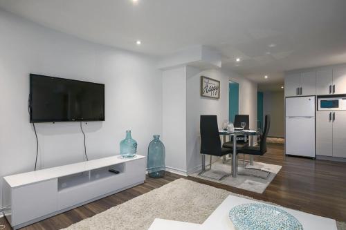 a living room with a flat screen tv on a wall at Tranquille Discret Privé in Laval